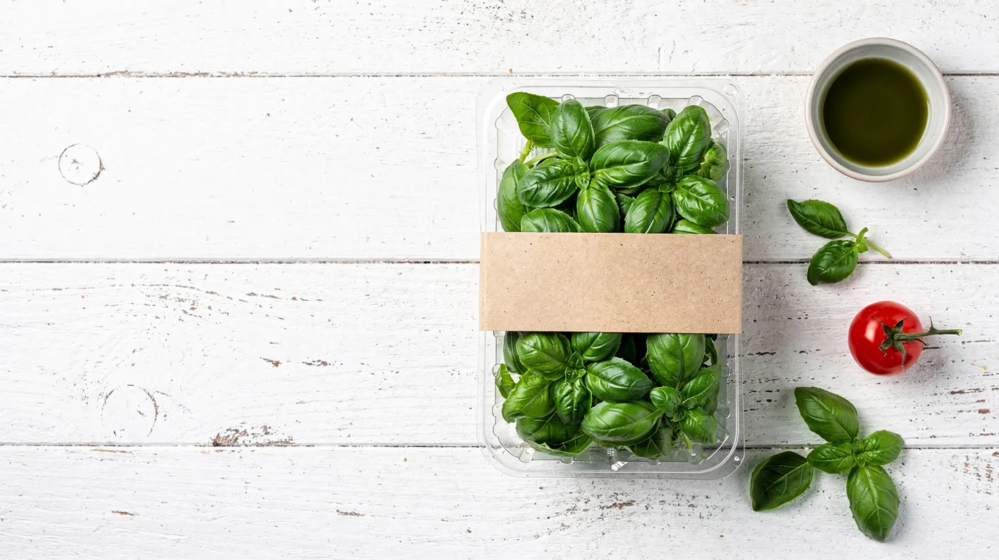 Basil 20g punnet, packed by Harvest Lane Herbs, on white timber